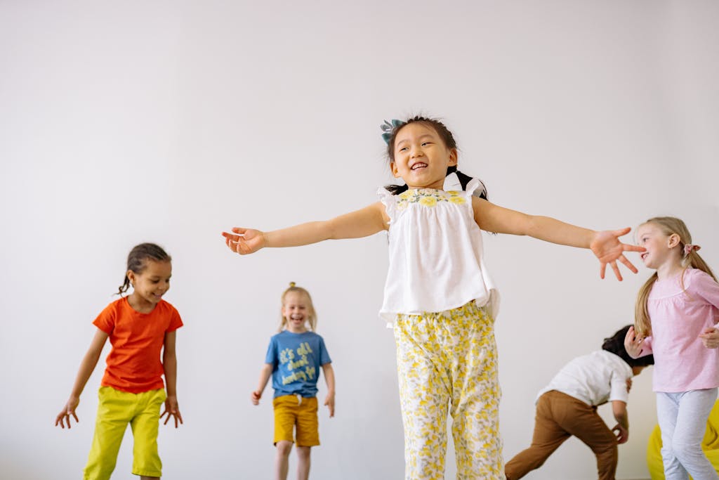 Group of diverse children joyfully dancing and playing inside a bright room, capturing happiness.