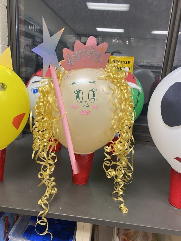 Student made princess parade balloon with a glitter crown, star wand, and curly ribbon hair